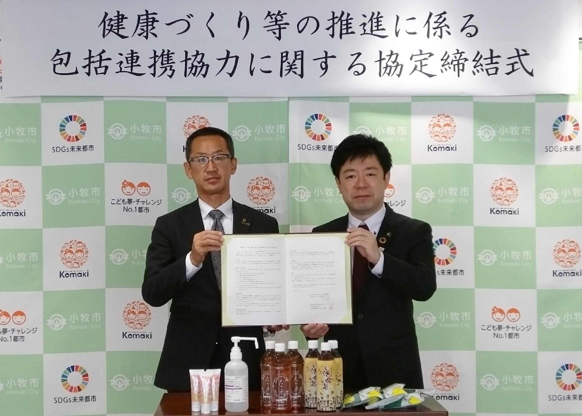 協定書を持った中北薬品株式会社の山本常務取締役と山下市長