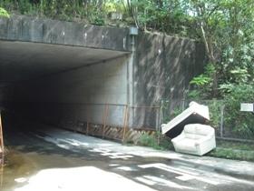 （写真）トンネルの出入り口横にソファーが投棄されている、不法投棄現場の様子