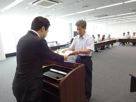 第10回地域協議会市民会議で山下市長から落合委員へ委嘱状を手渡している様子の写真