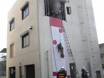 建物の3階から救助者がロープでつられている写真