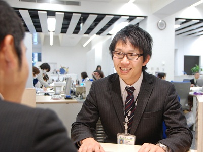 市役所窓口で笑顔で接客する職員