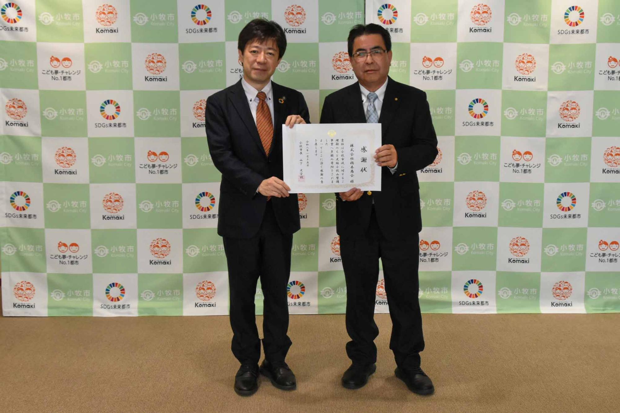 山下市長から表彰状を受け取る様子