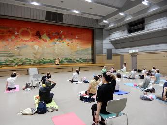 ヨガマットや椅子に座ってストレッチをしている様子