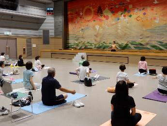 ヨガマットの上で先生の指導の下呼吸法を学んでいるところ