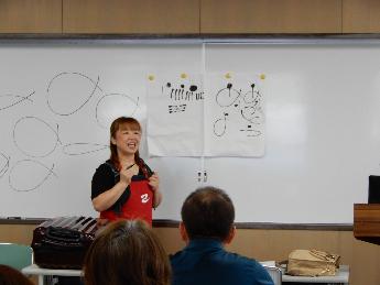 ホワイトボードを使って己書の書き方を説明しているようす