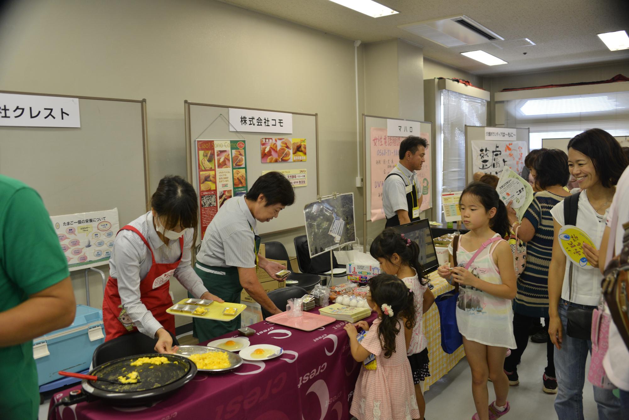 展示ブースにて試食する人々